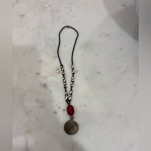 Necklace with coil metal design and burgundy bead